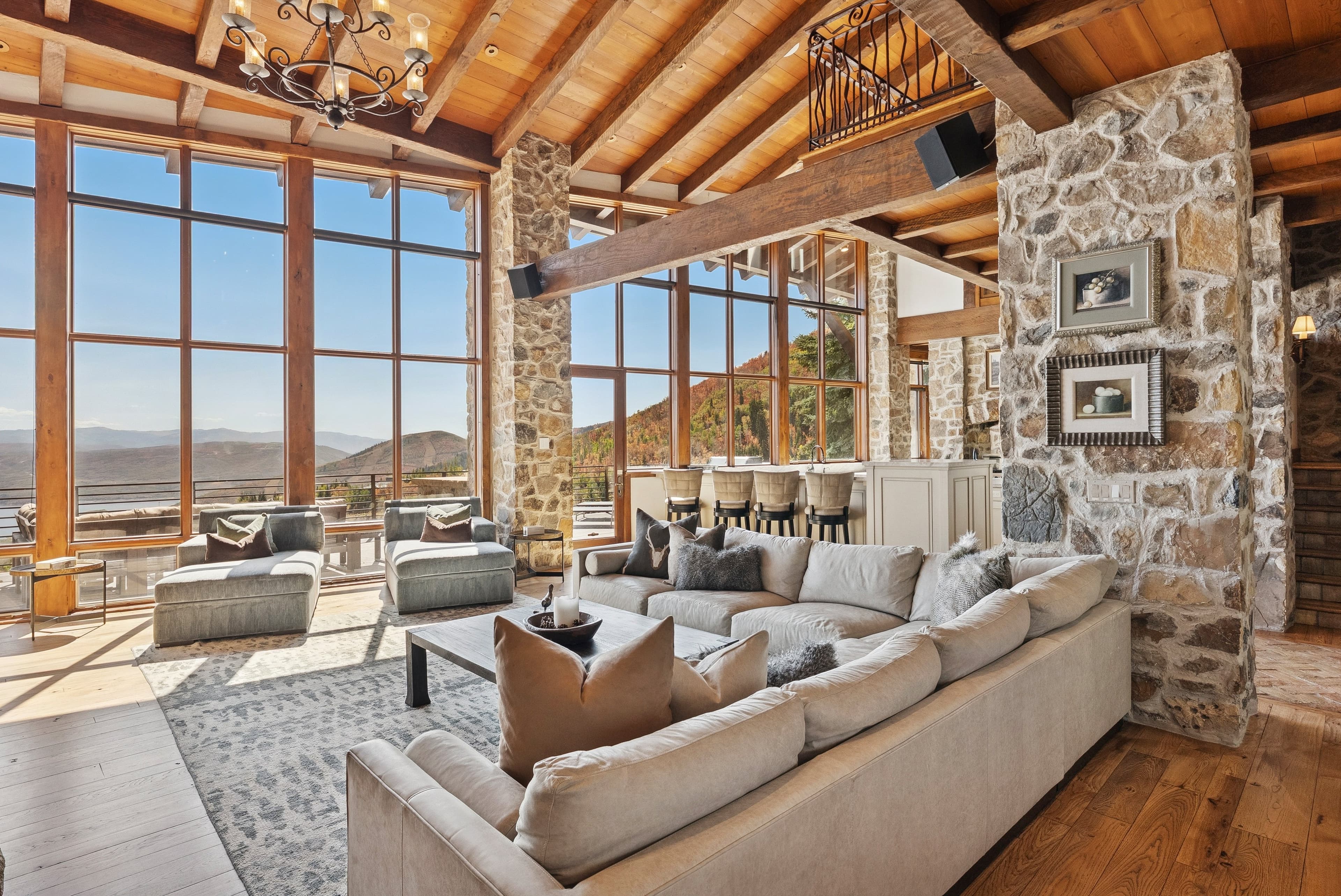 Bright living room with expansive windows, neutral sectional, and panoramic valley views.