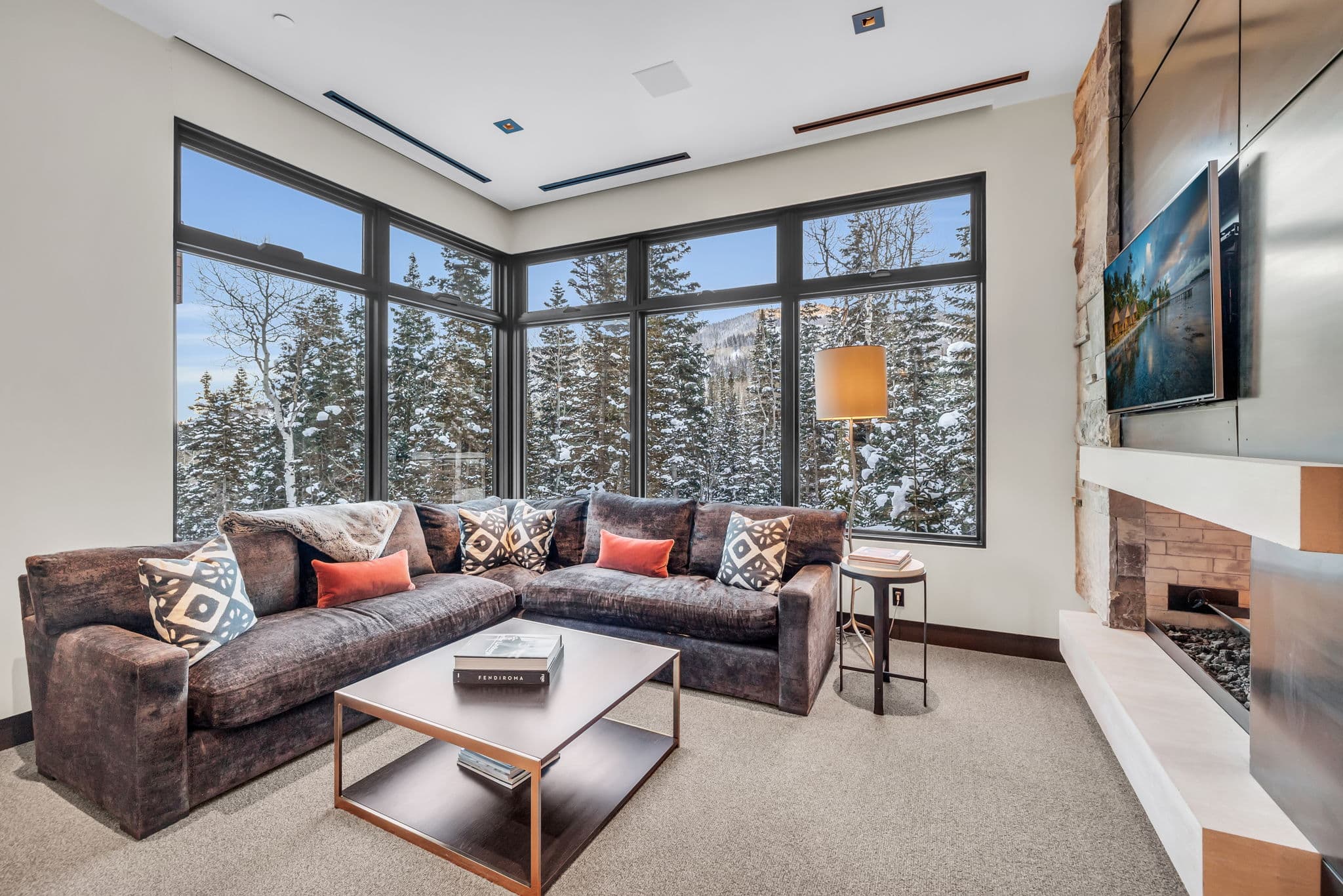 A cozy lounge with panoramic windows and a fireplace.