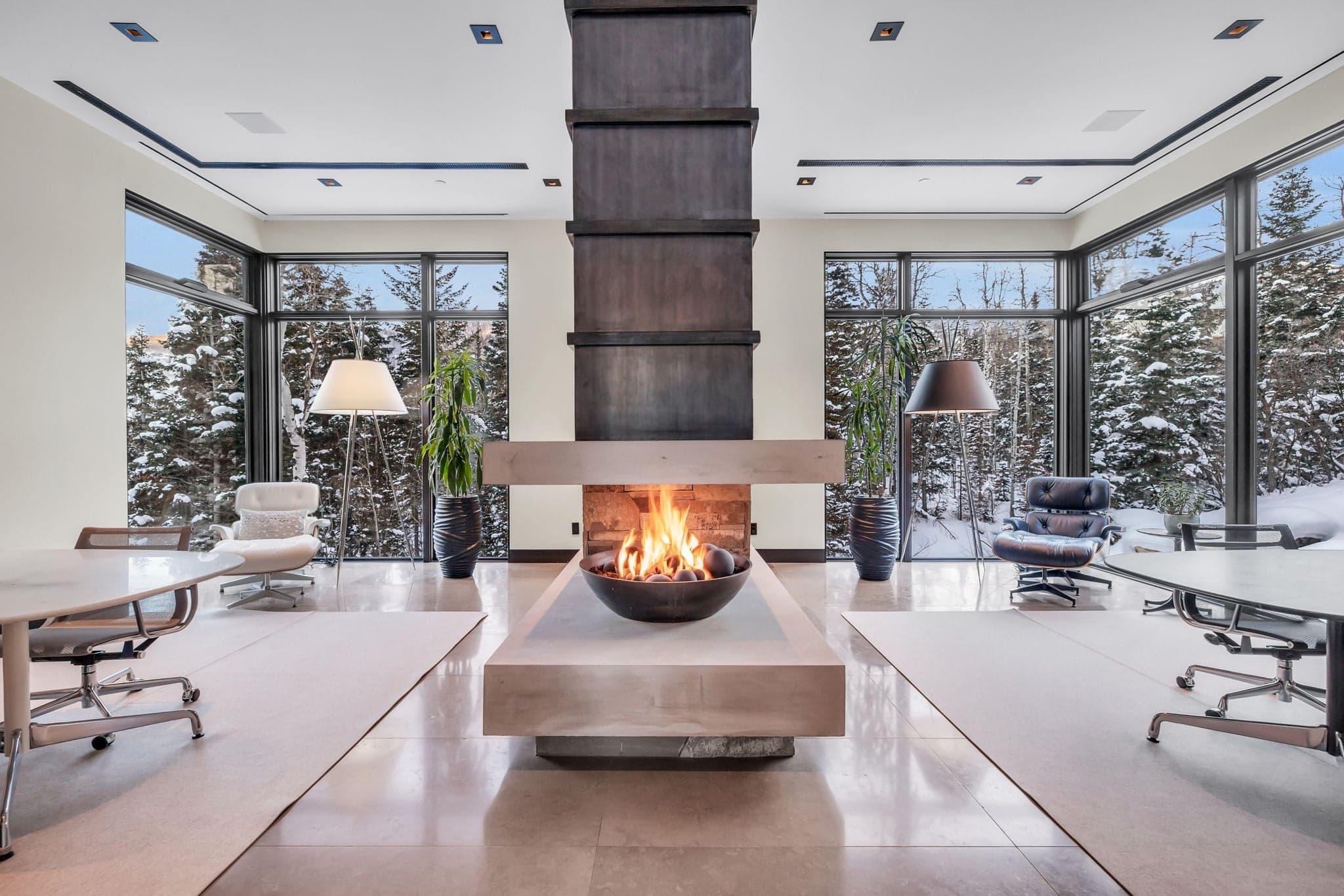 A stunning lounge with a statement fireplace and snowy views.