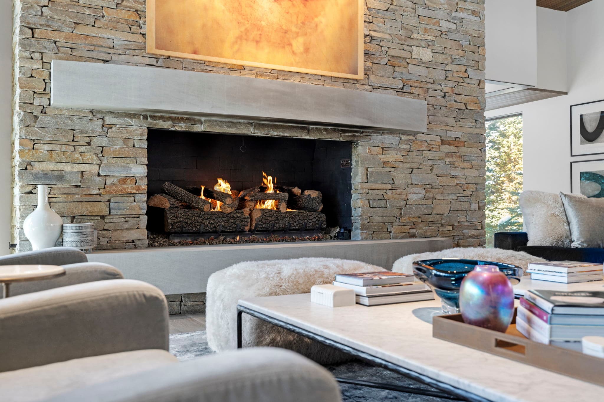 A close-up view of a fireplace, coffee table, and chairs.