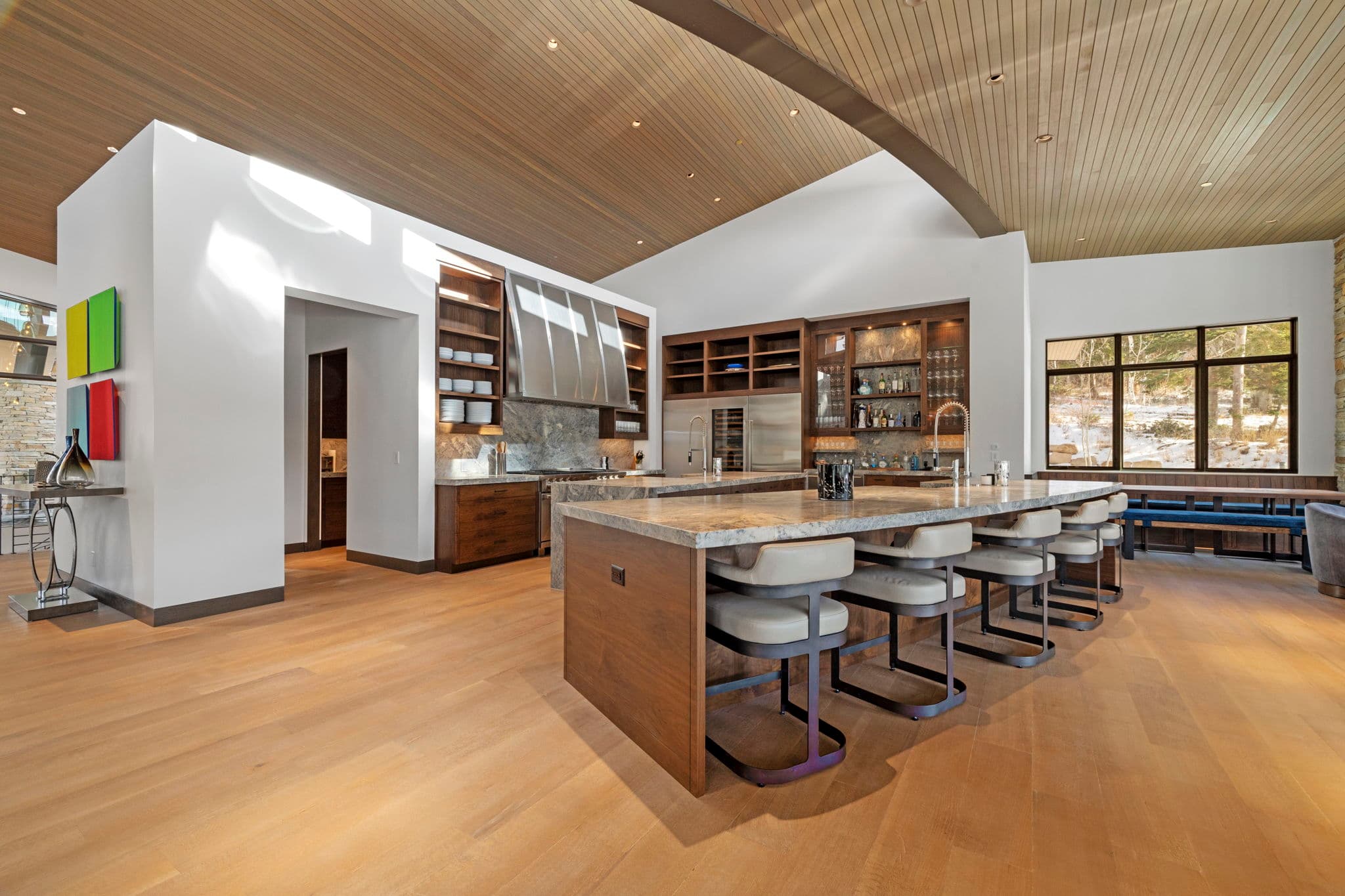 A large kitchen with a bar and five bar stools.