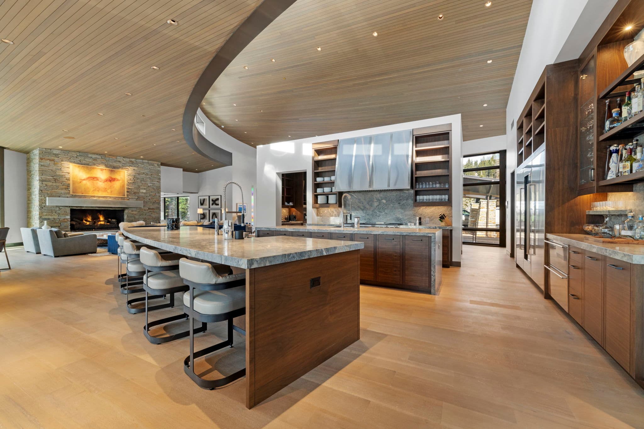 A view of the kitchen with a bar and chairs.