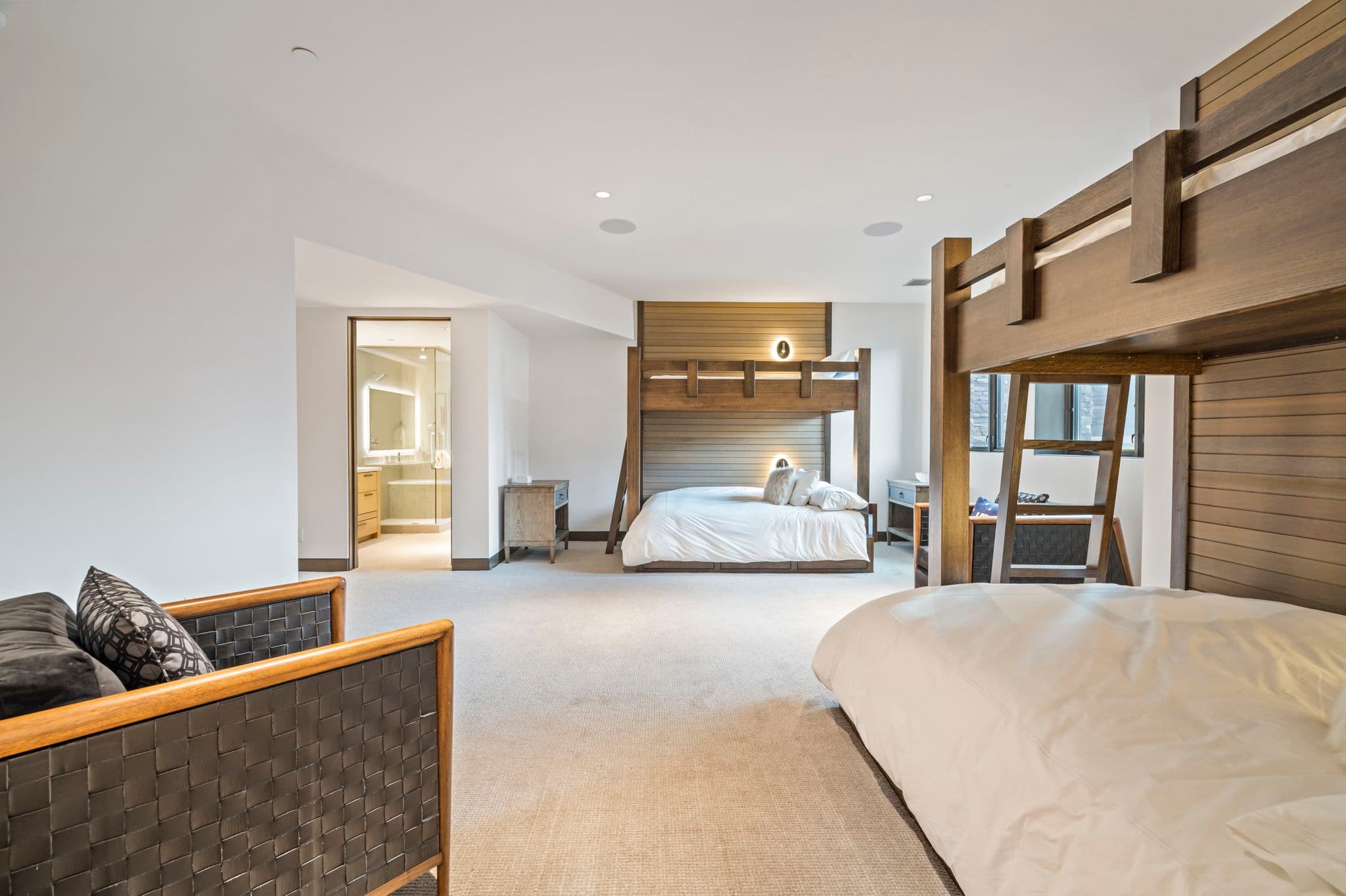 A bedroom with two bunk beds and a chair.