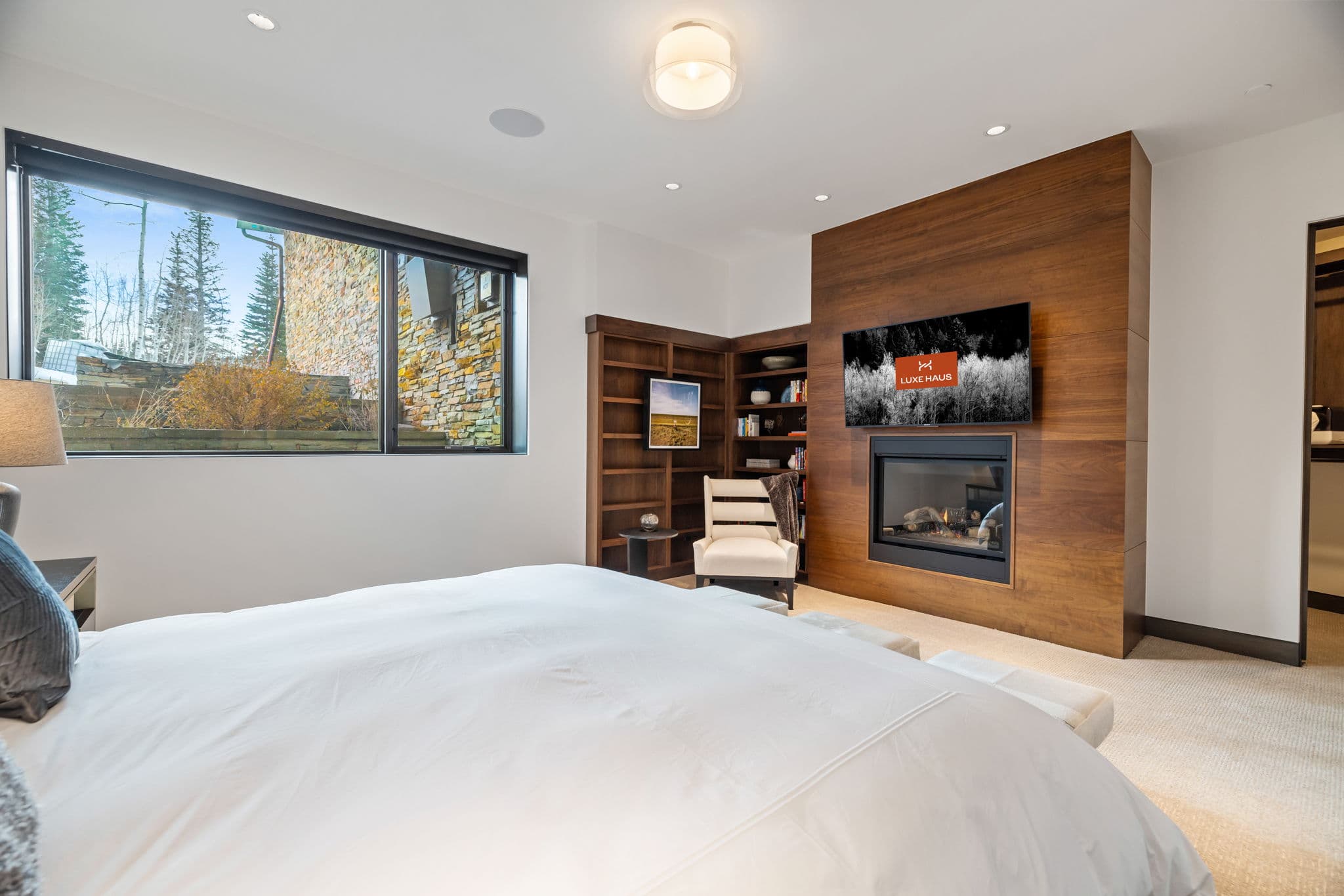 A bedroom with a seating area and a fireplace.