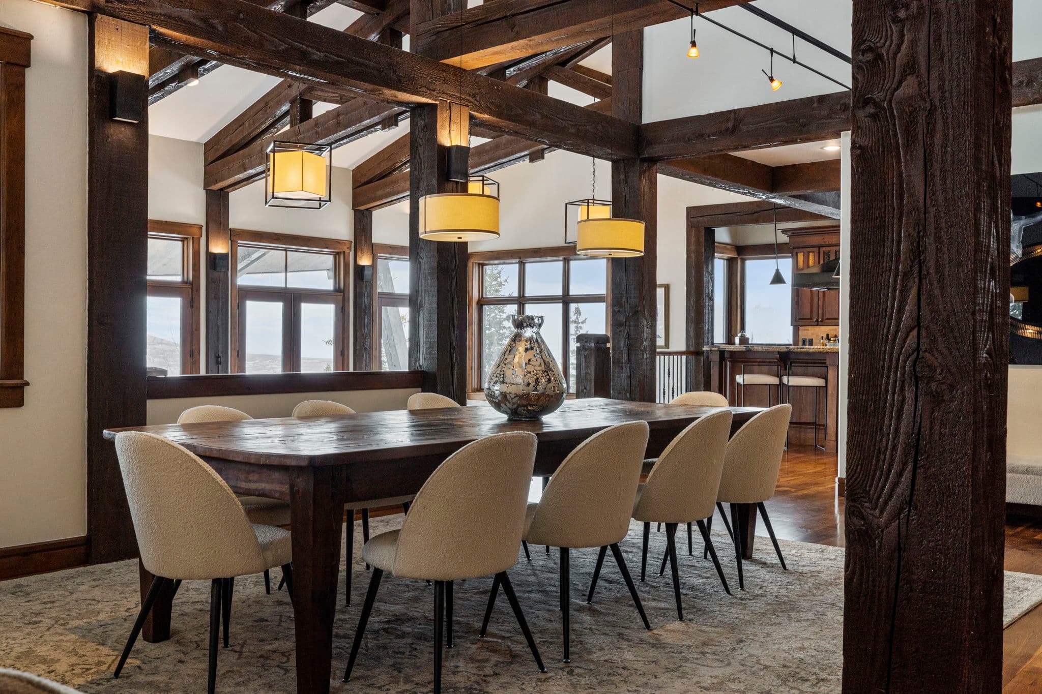 a long dining table in an elegant dining room with mountain views