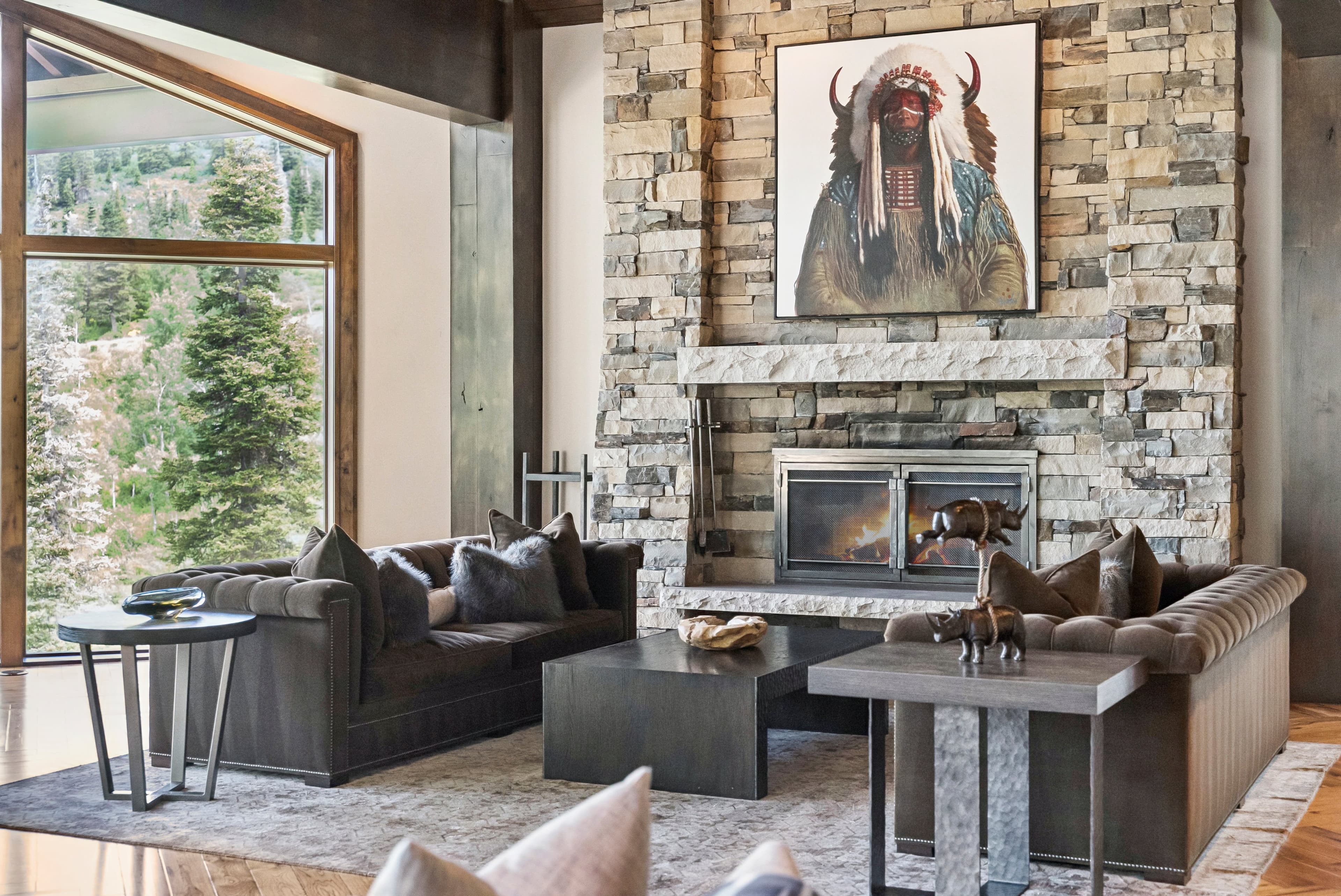 a stunning seating area with overstuffed couches, a large fireplace and stunning artwork above the mantle